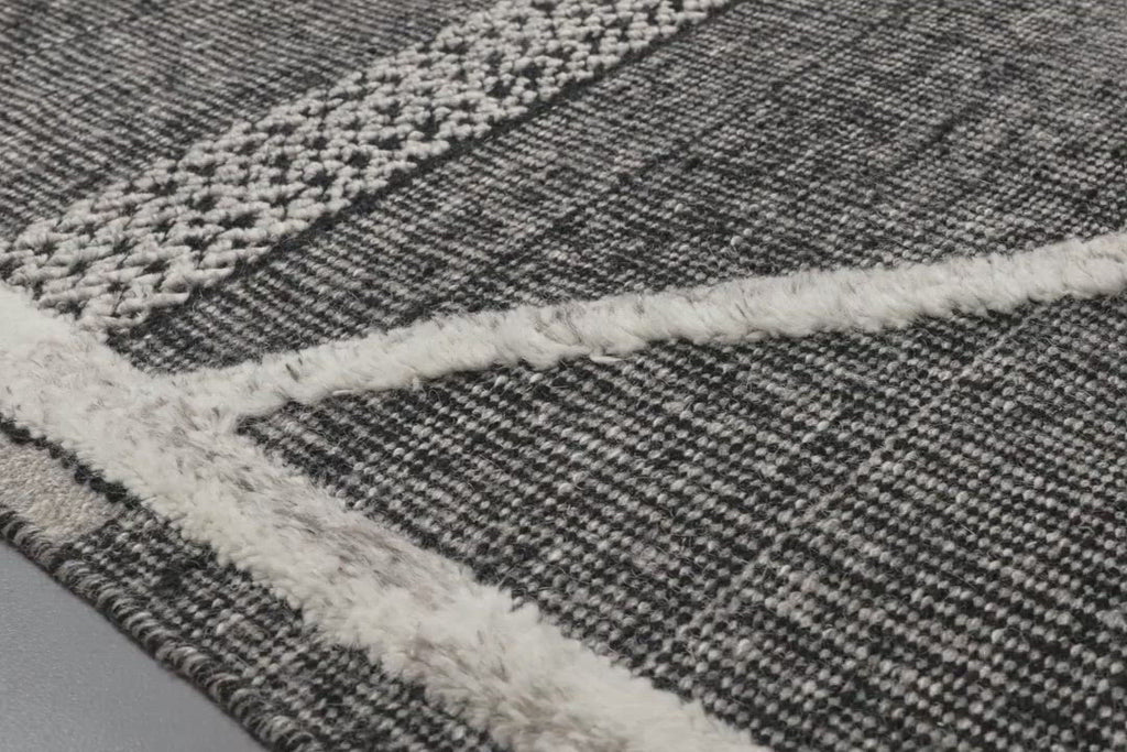 A new take on Moroccan style rugs, the Iman Collection is hand-knotted of 100% wool pile by skilled artisans in India. The surface features linear and braided details, creating tonal variations that make each piece unique. Plus, each design is finished with playful fringe.  Hand Knotted 100% Wool Pile IMA-02 Beige / Charcoal